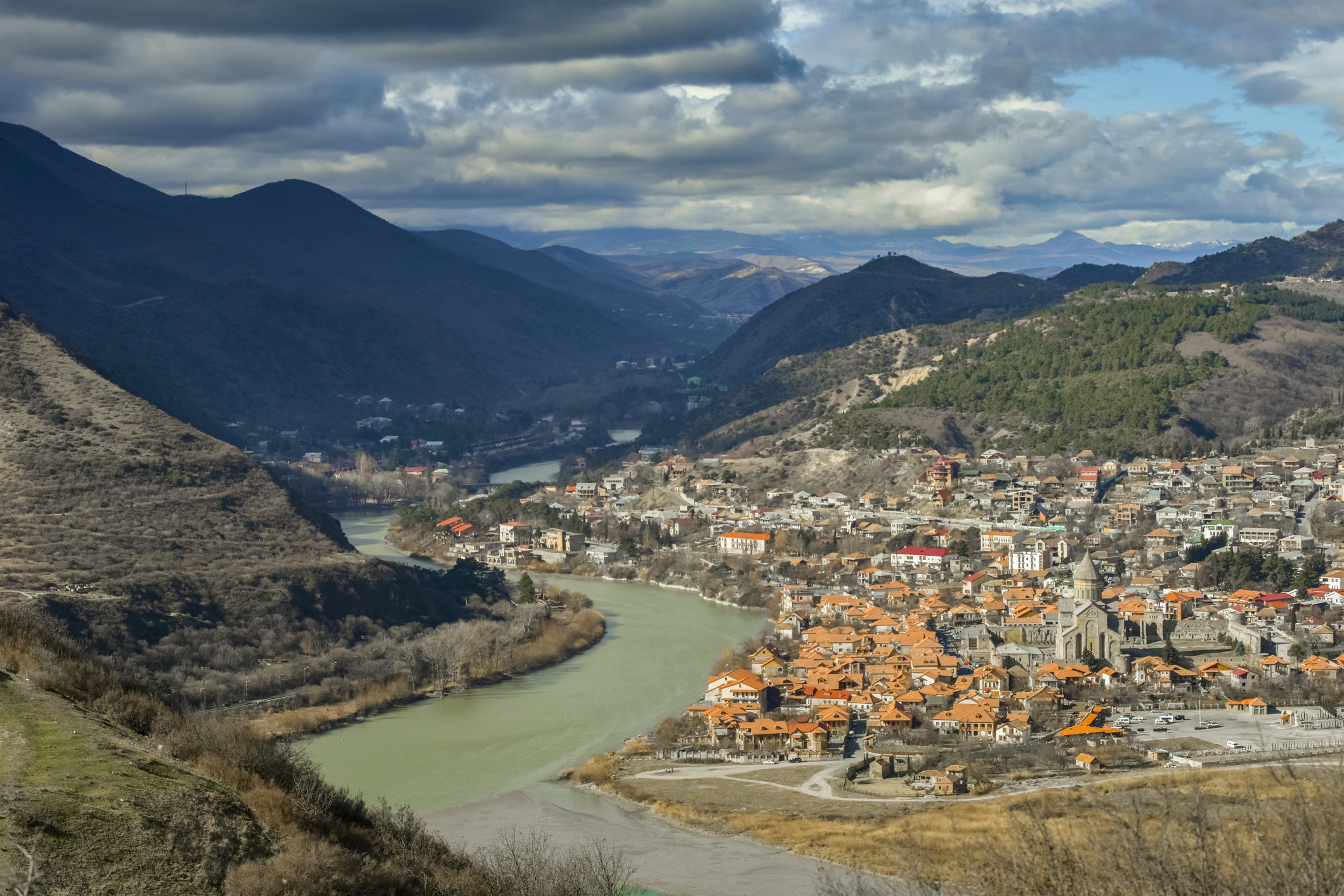 A town built into the mountains with a river running next to it