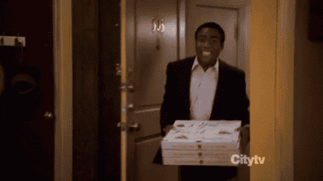 Troy walking into his apartment holding pizzas to find chaos and fire