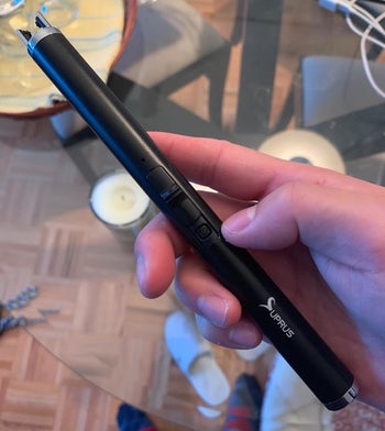 a reviewer hand holding the lighter in black