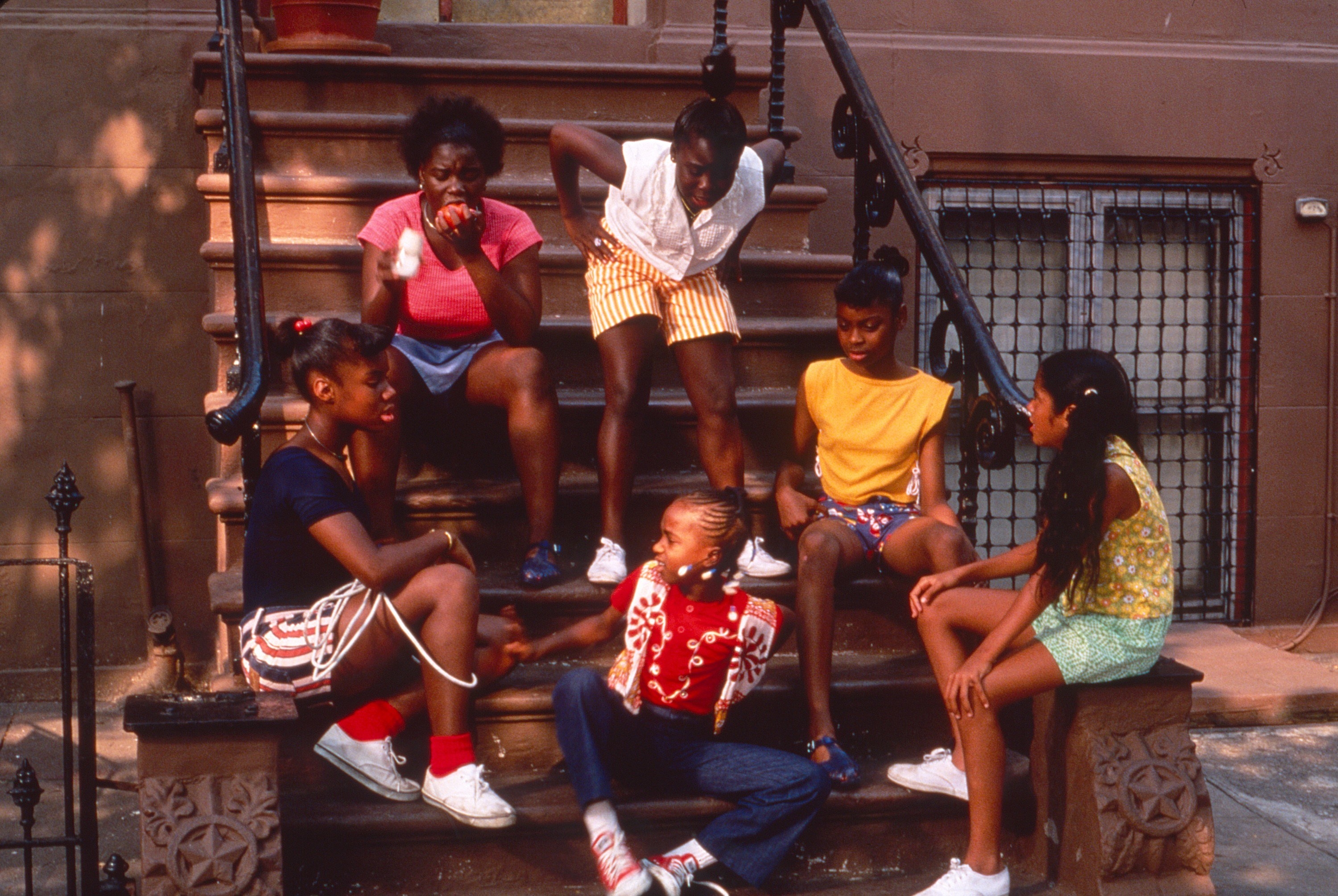 The cast members sitting on a stoop