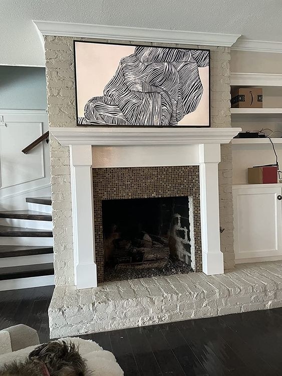 a reviewer&#x27;s picture of their tv disguised as modern art on their mantel