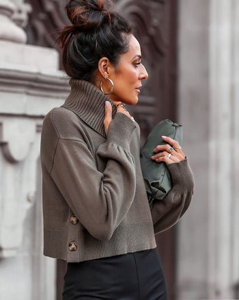 Side view of a model wearing the olive green turtleneck showing the side buttons