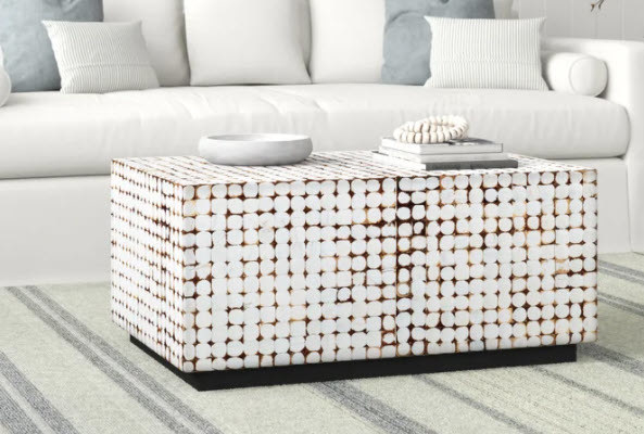A solid wood block coffee table that is rectangular shaped and made out of recycled coconut shells designed intricately around the table