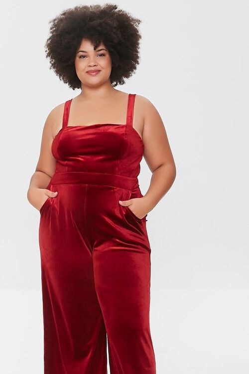 a model wears the red jumpsuit with their hands in the pockets