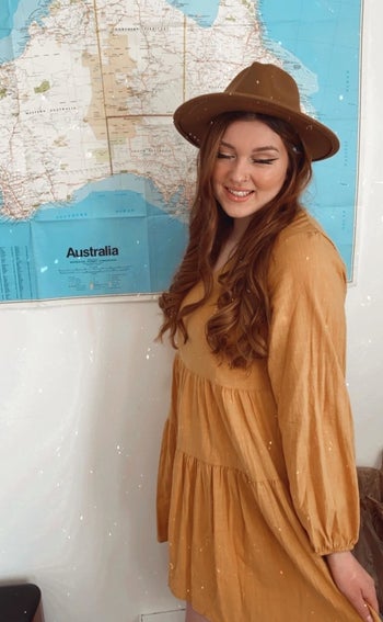 a different reviewer wearing the yellow dress with a tan hat