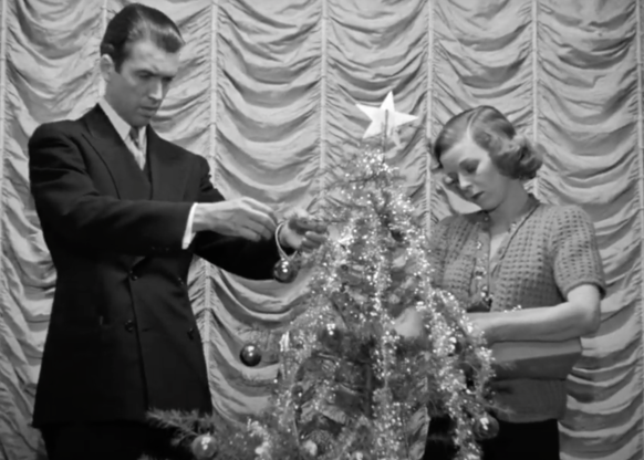 Jimmy Stewart and Margaret Sullivan decorating a Christmas tree
