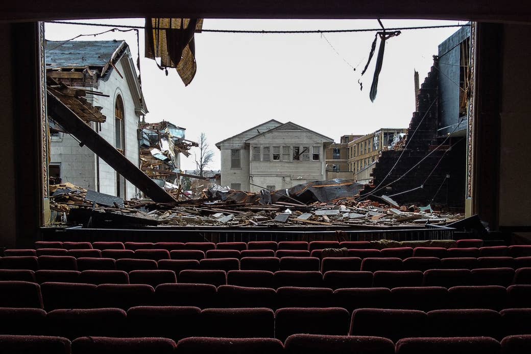 A movie theater with the screen ripped off to show destruction and houses