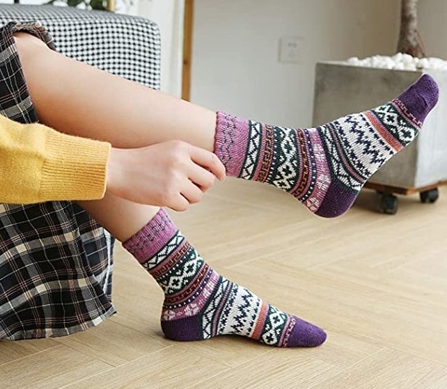 A person pulling on a patterned crew sock
