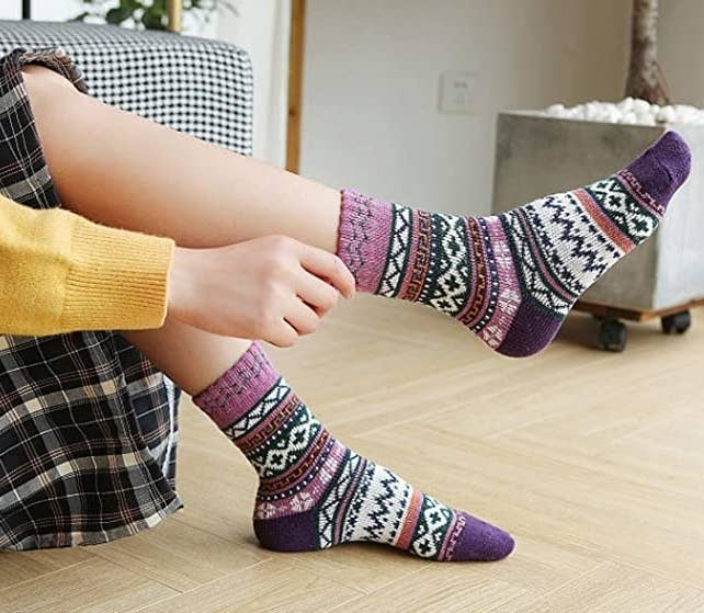 A person pulling on a patterned crew sock