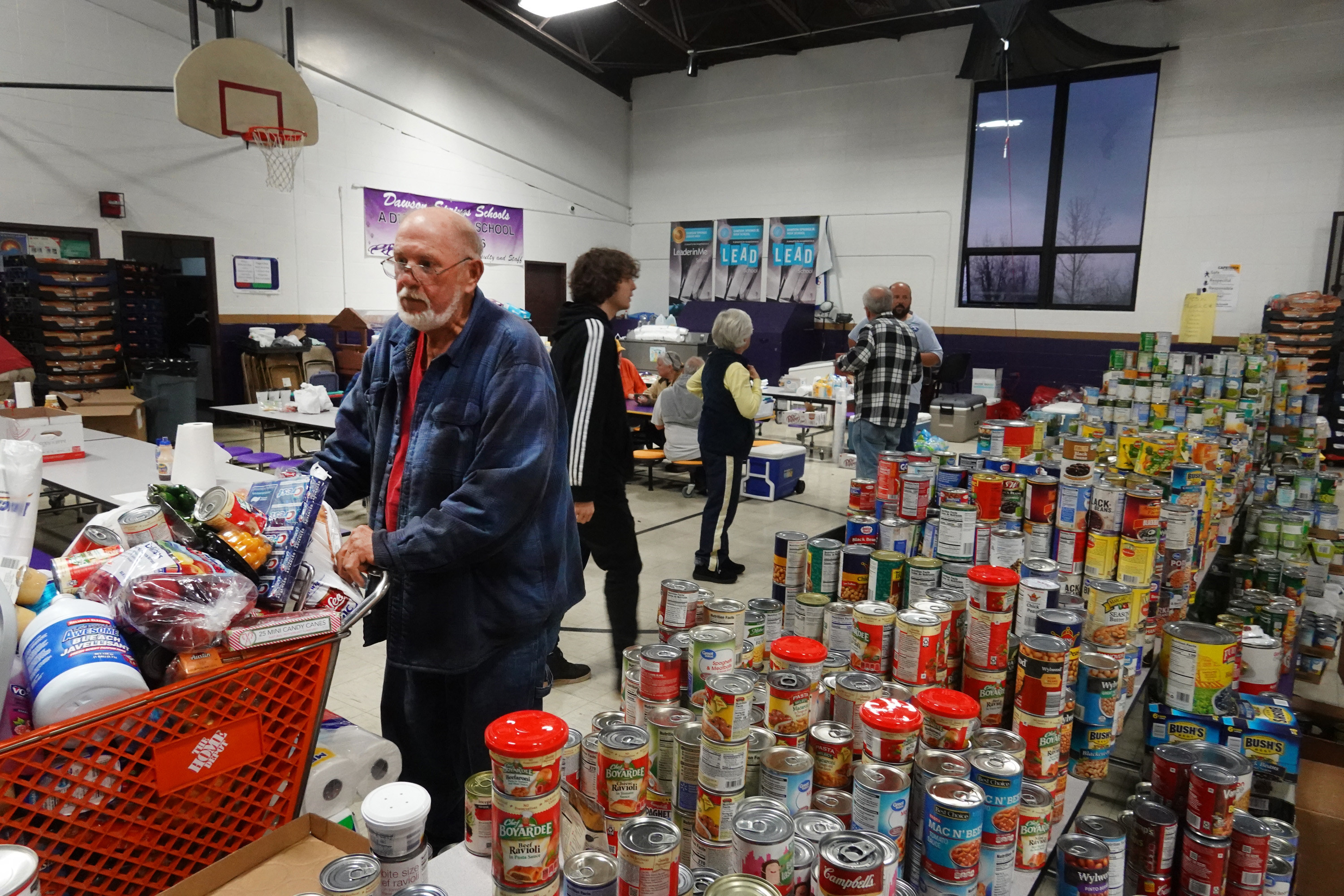 A man pushes a home depot cart full of food through a relief supple stop in kentucky