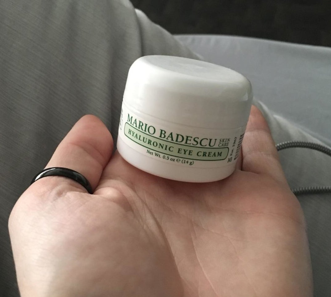 Reviewer holding white and green container of eye cream that reads &quot;Mario Badescu hyaluronic eye cream&quot;