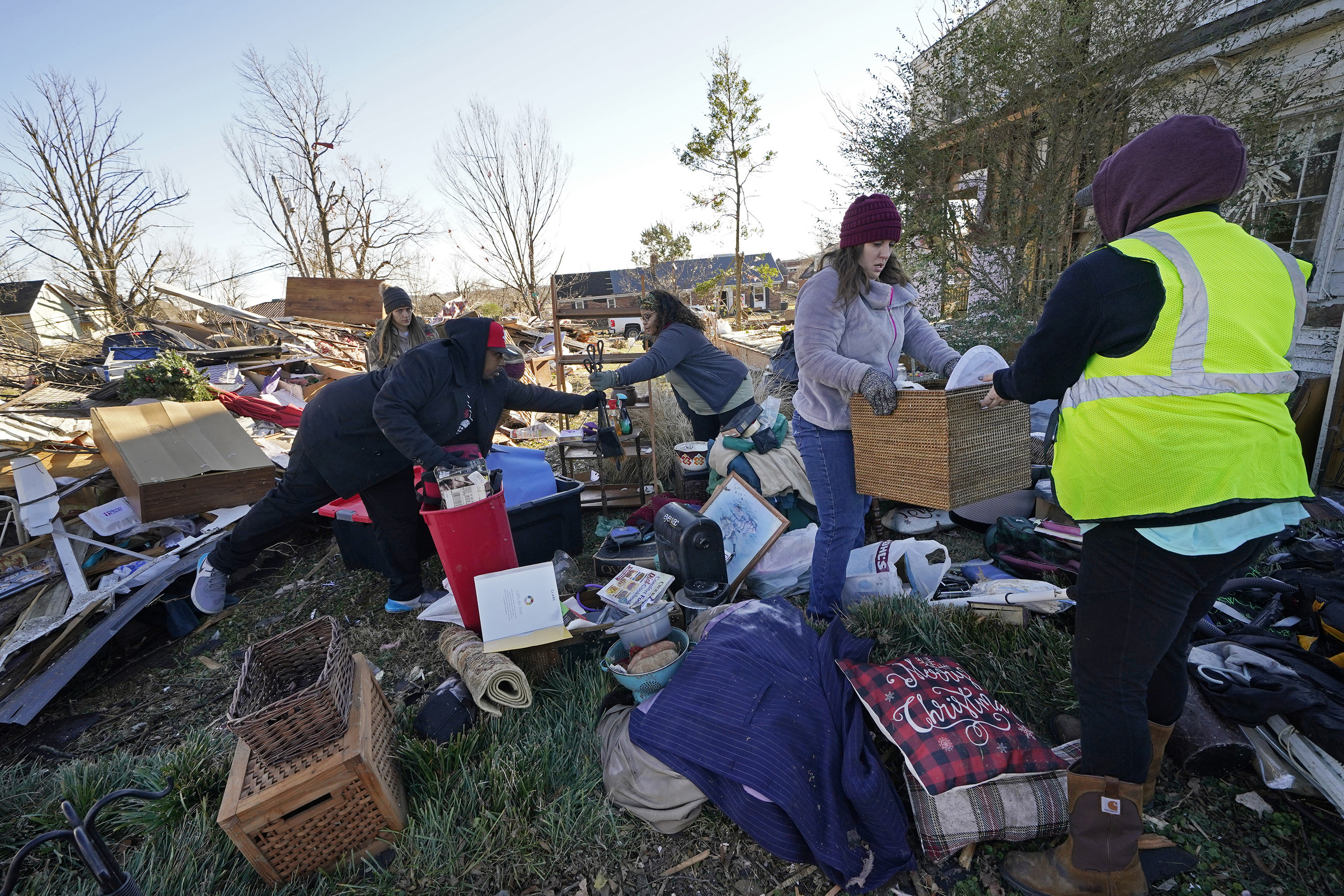 Four women pick up baskets, boxes, and merry christmas decorations 