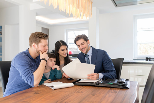 An insurance agent looks over a policy with a family.