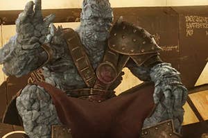 A close up of Korg as he waves at someone off screen