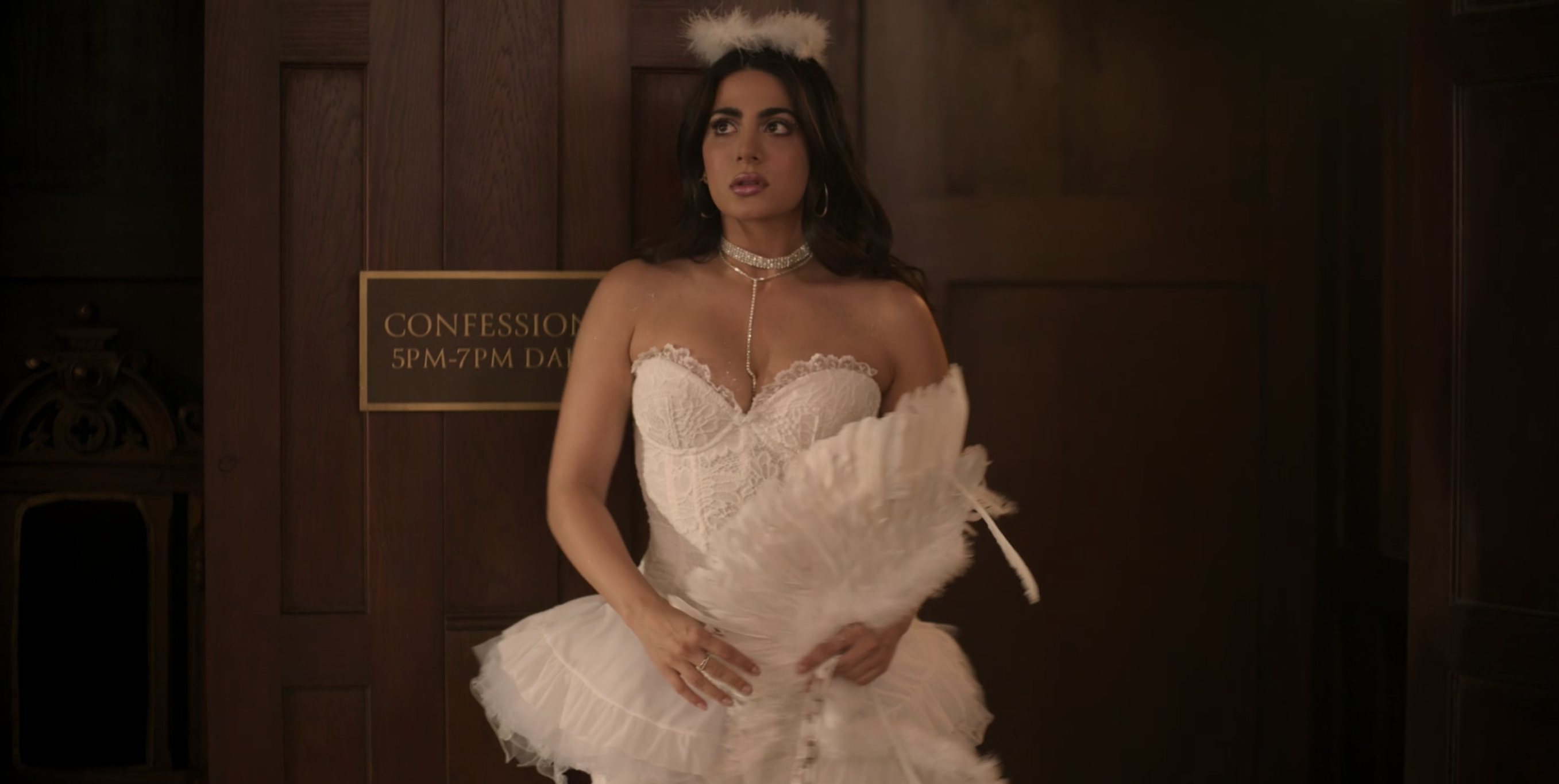 Lily stepping out of a confessional while in an angel costume