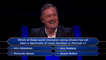 Piers Morgan on a game show laughing and looking down