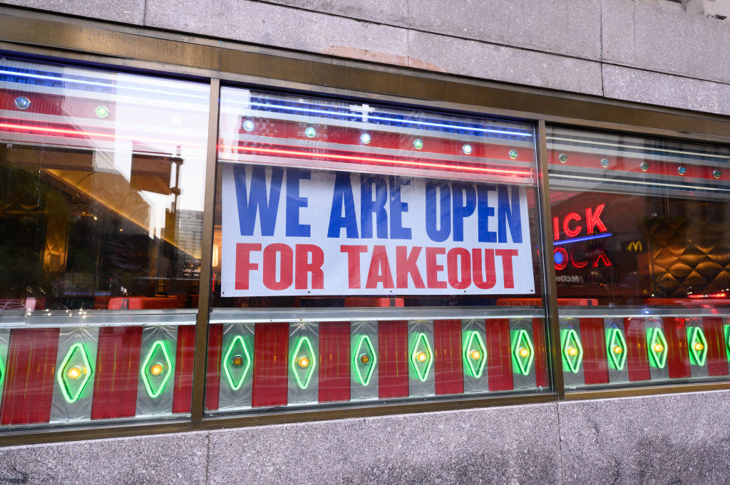 A restaurant window with a sign that says &quot;We are open for takeout&quot;