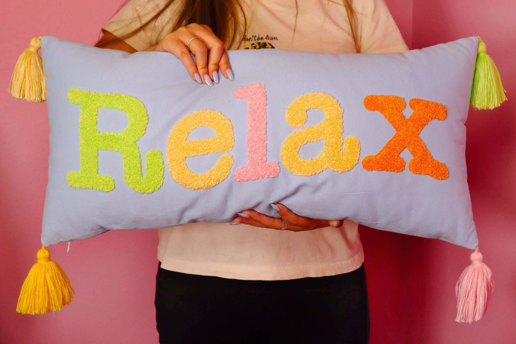 horizontal throw pillow that says RELAX on it