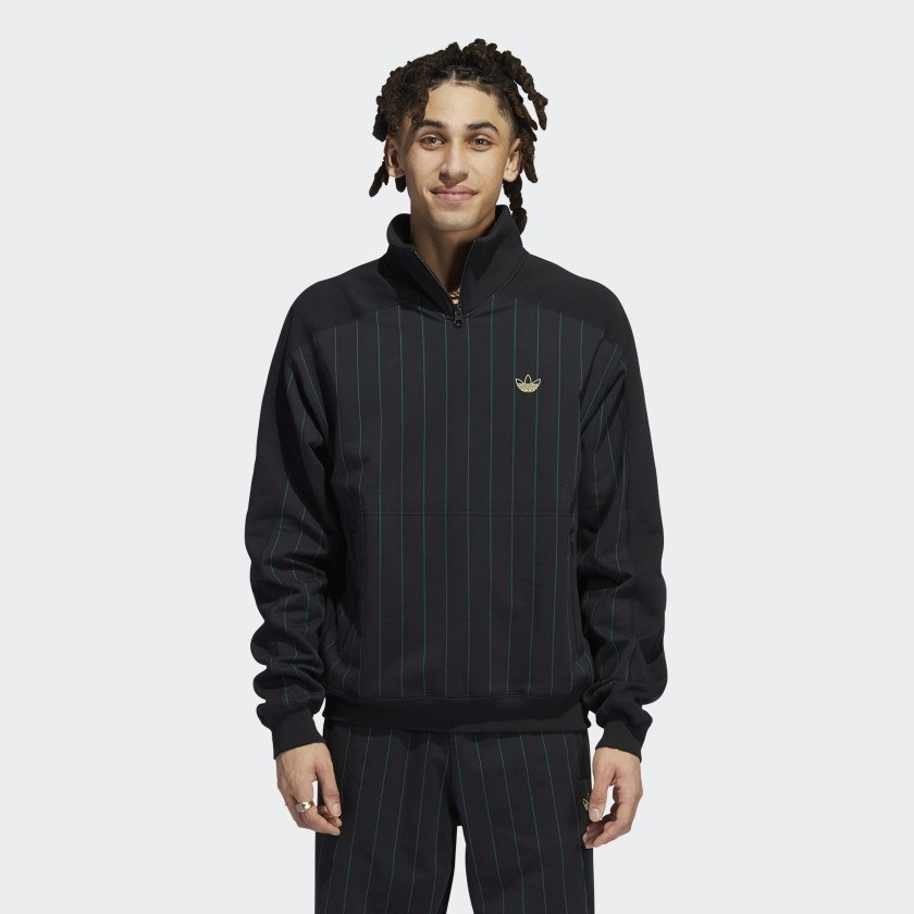 The black sweat top has green pin vertical stripes and a gold logo