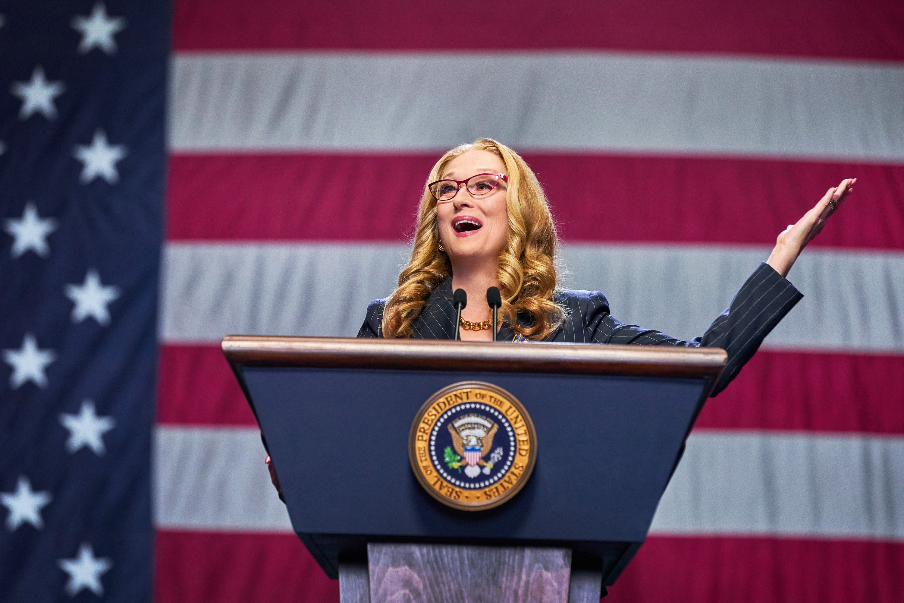 Meryl&#x27;s character giving a speech with a gigantic U.S. flag behind her