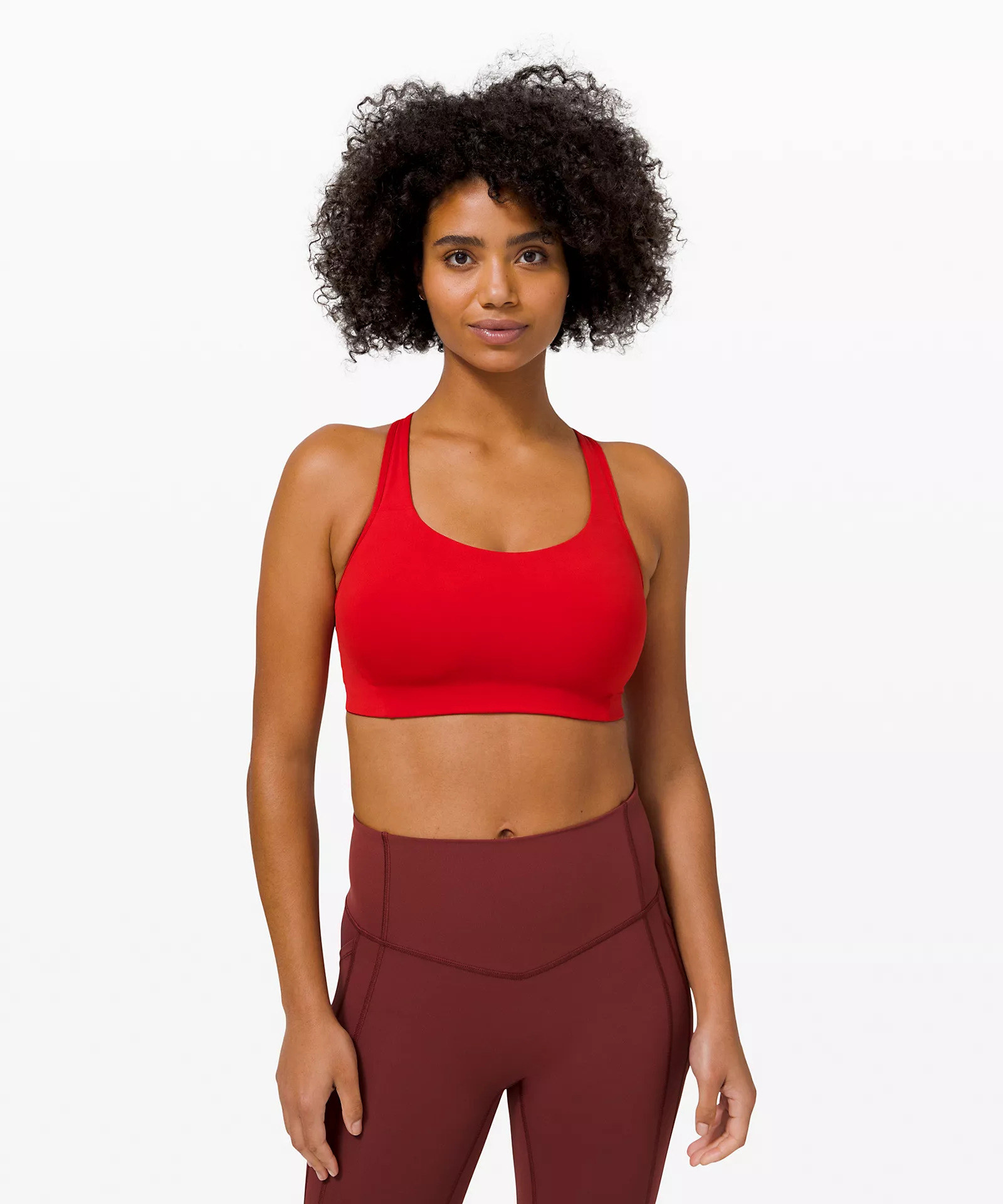model wears medium support bright red sports bra with burgundy leggings