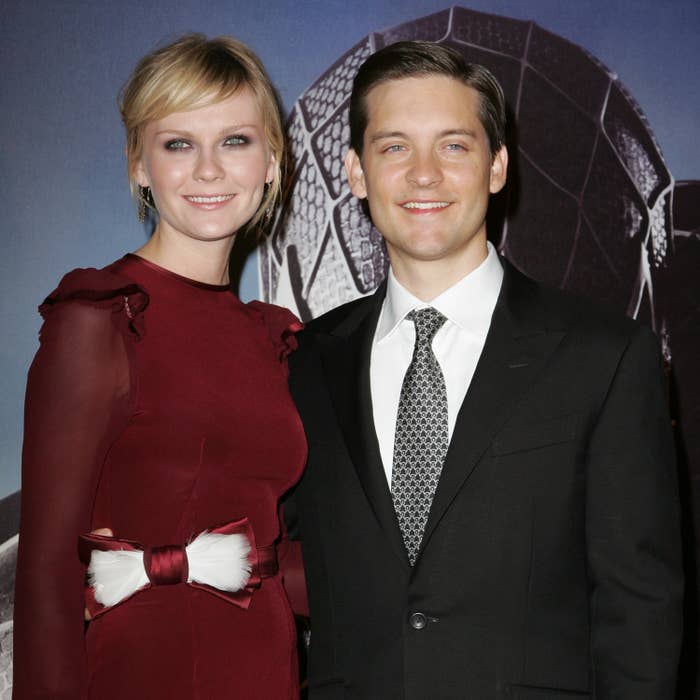 Kirsten and Tobey smile at a red carpet event