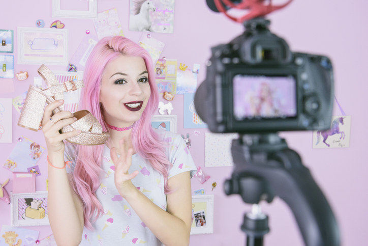 An influencer holding up a platform shoe as they film a video