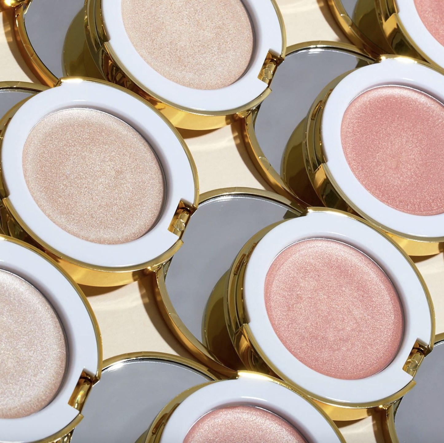 A collection of cream highlighters in gold compacts