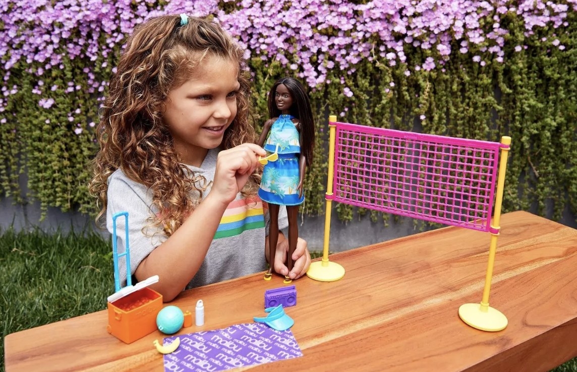 A child playing with the Barbie beach volleyball toys