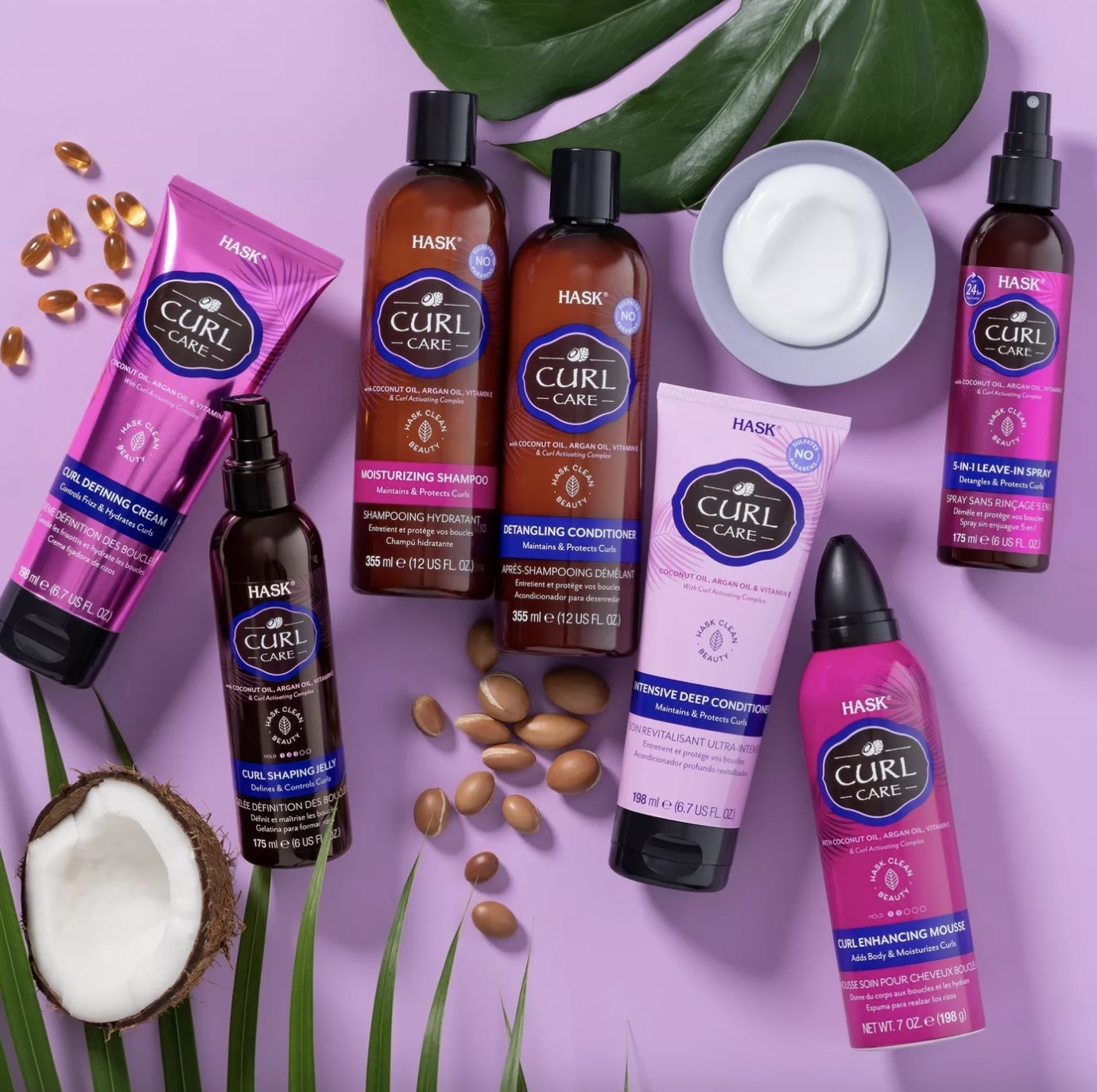 A collection of curl enhancing products that include a mousse, cream, leave-in spray, shampoo, conditioner, and deep conditioner