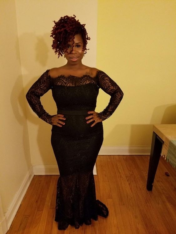 reviewer in the black form-fitting dress with long lace sleeves