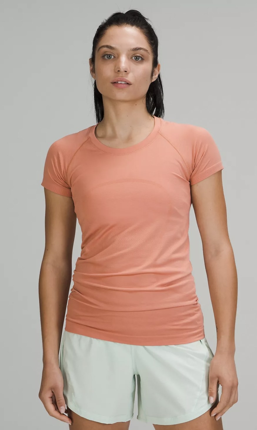 front view of model wearing the fitted t-shirt in coral