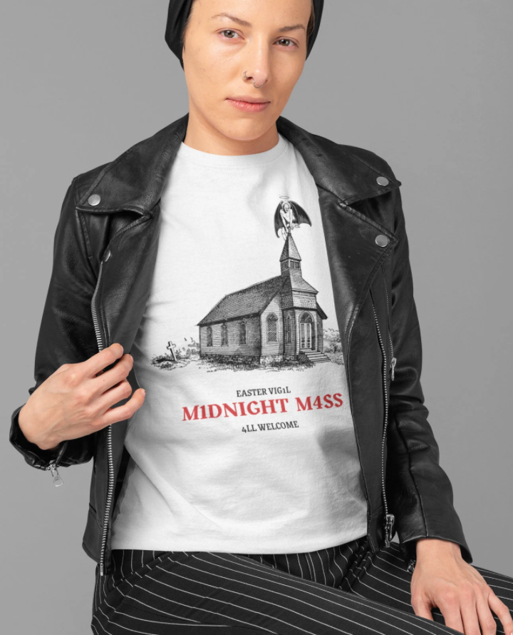 A T-shirt with a drawing of an old church and a demon sitting on top of the steeple saying Easter vigil Midnight Mass all welcome