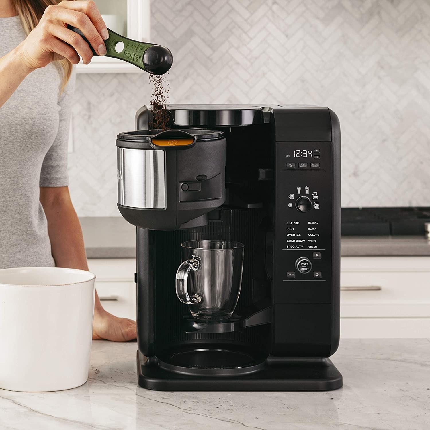 A person putting coffee grounds into the coffee maker