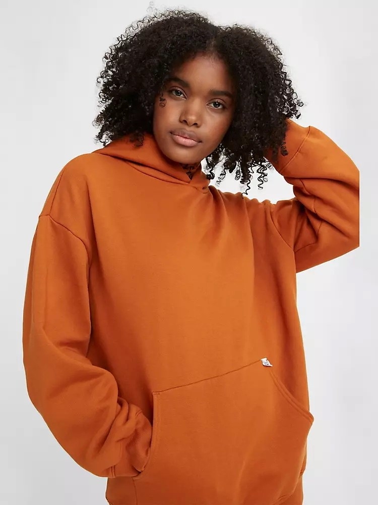 Model wearing orange hoodie