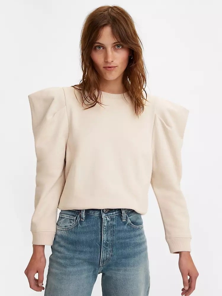 Model wearing white sweatshirt with big sleeves and jeans