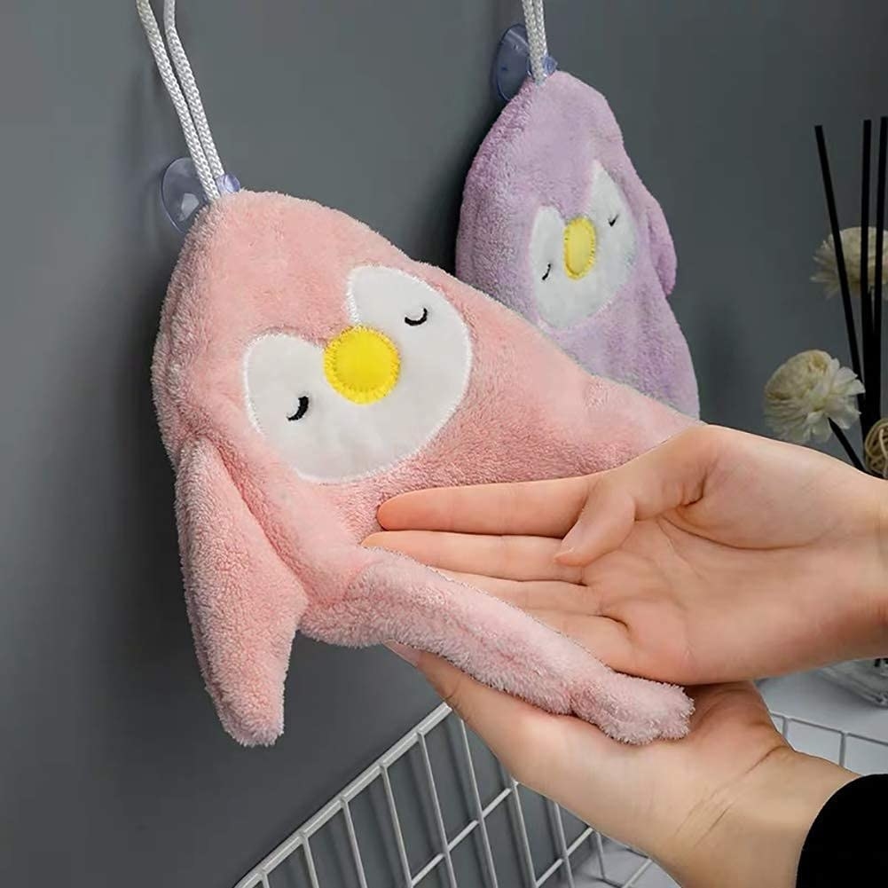 model dries hands on fluffy penguin-shaped towel
