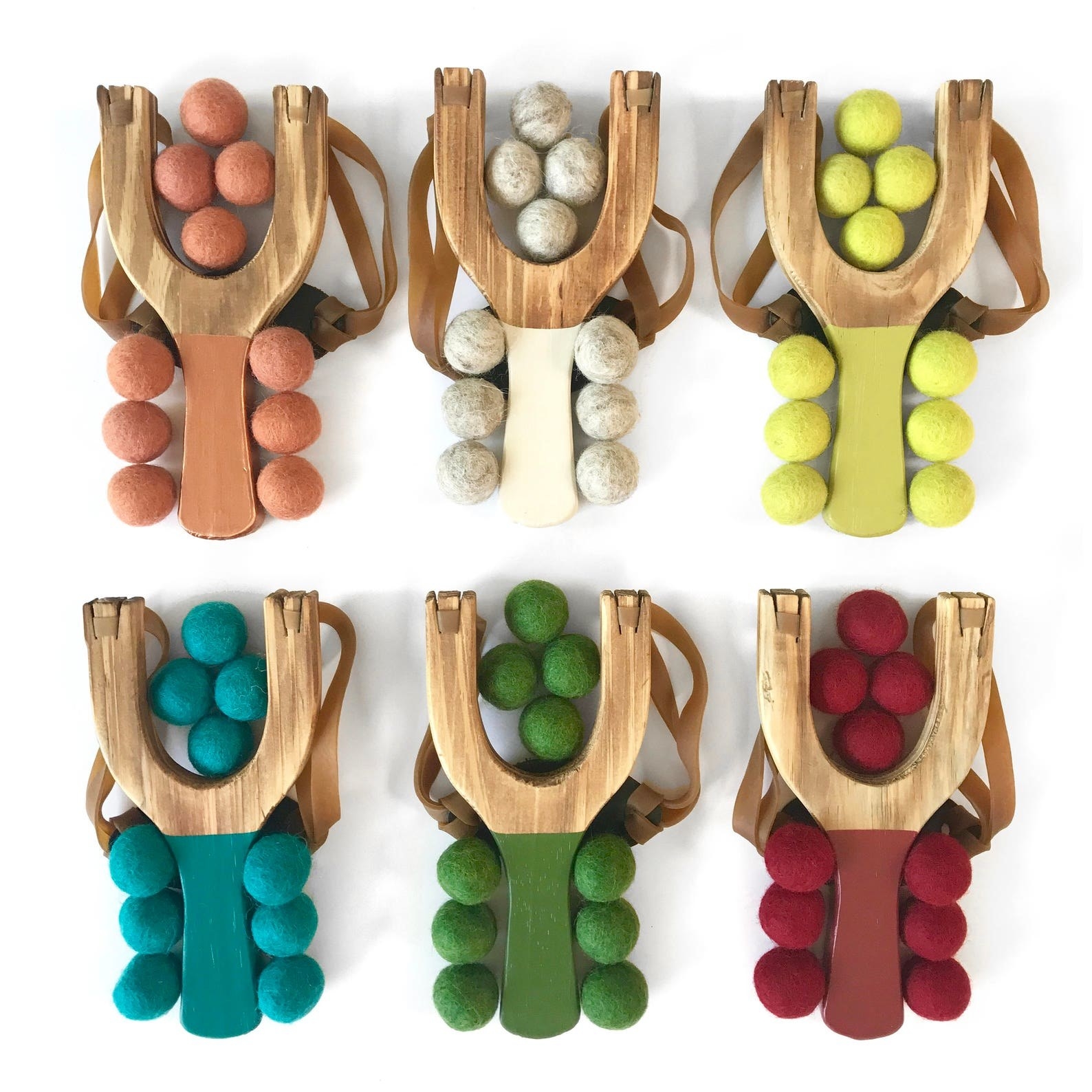 Six slingshots with multi-colored handles and pom balls