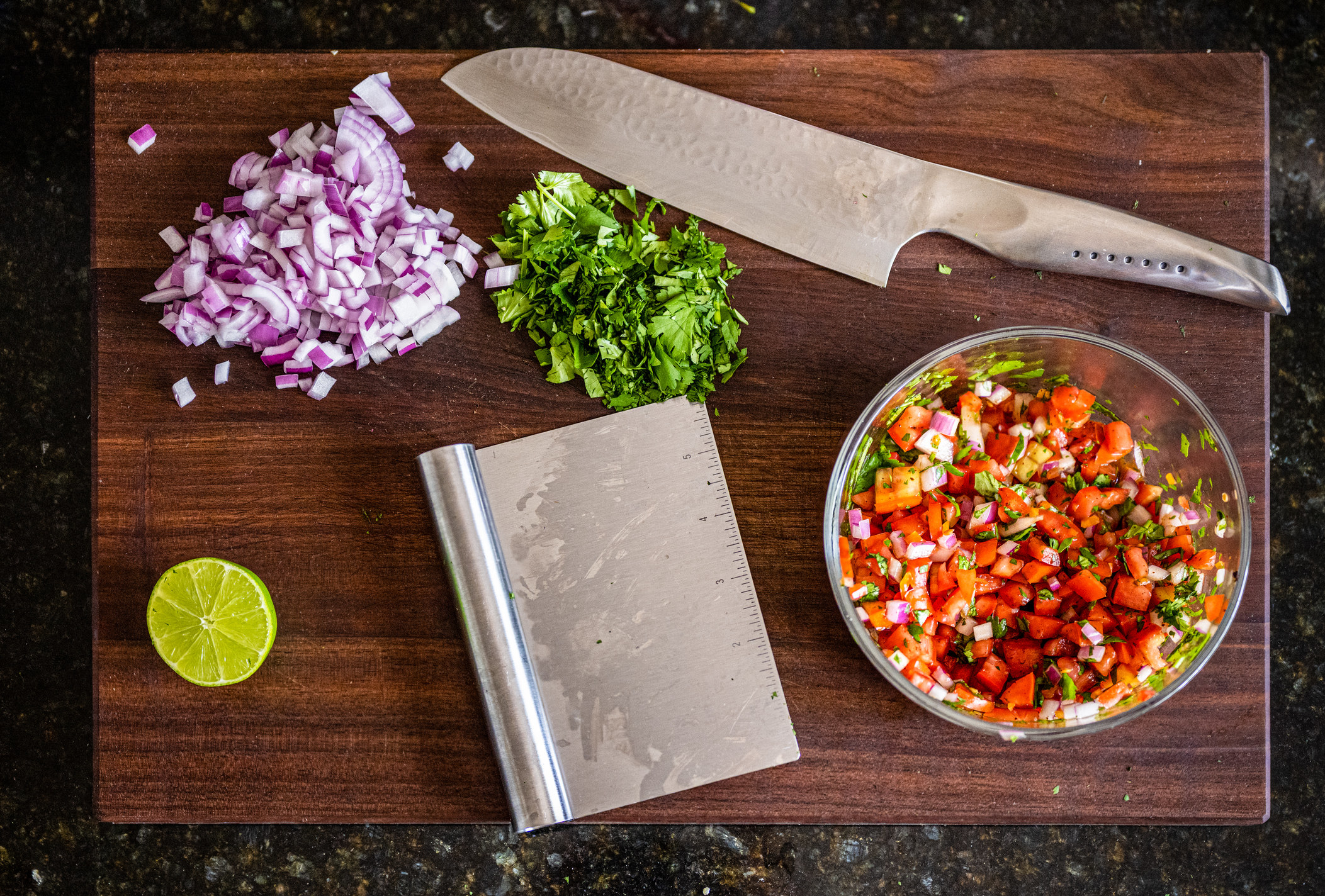 Pico de gallo ingredients on walnut cutting board.