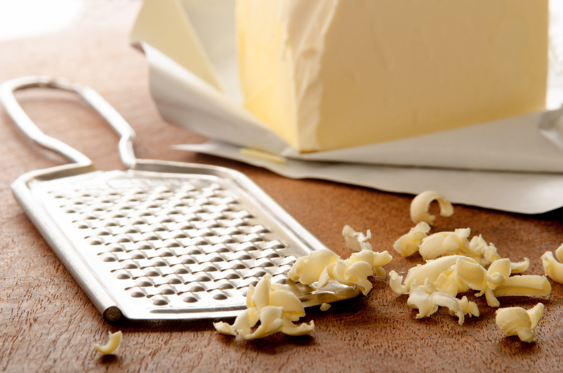 Grated butter on wooden board.