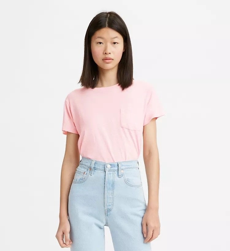 Model wearing pink shirt with pocket and jeans