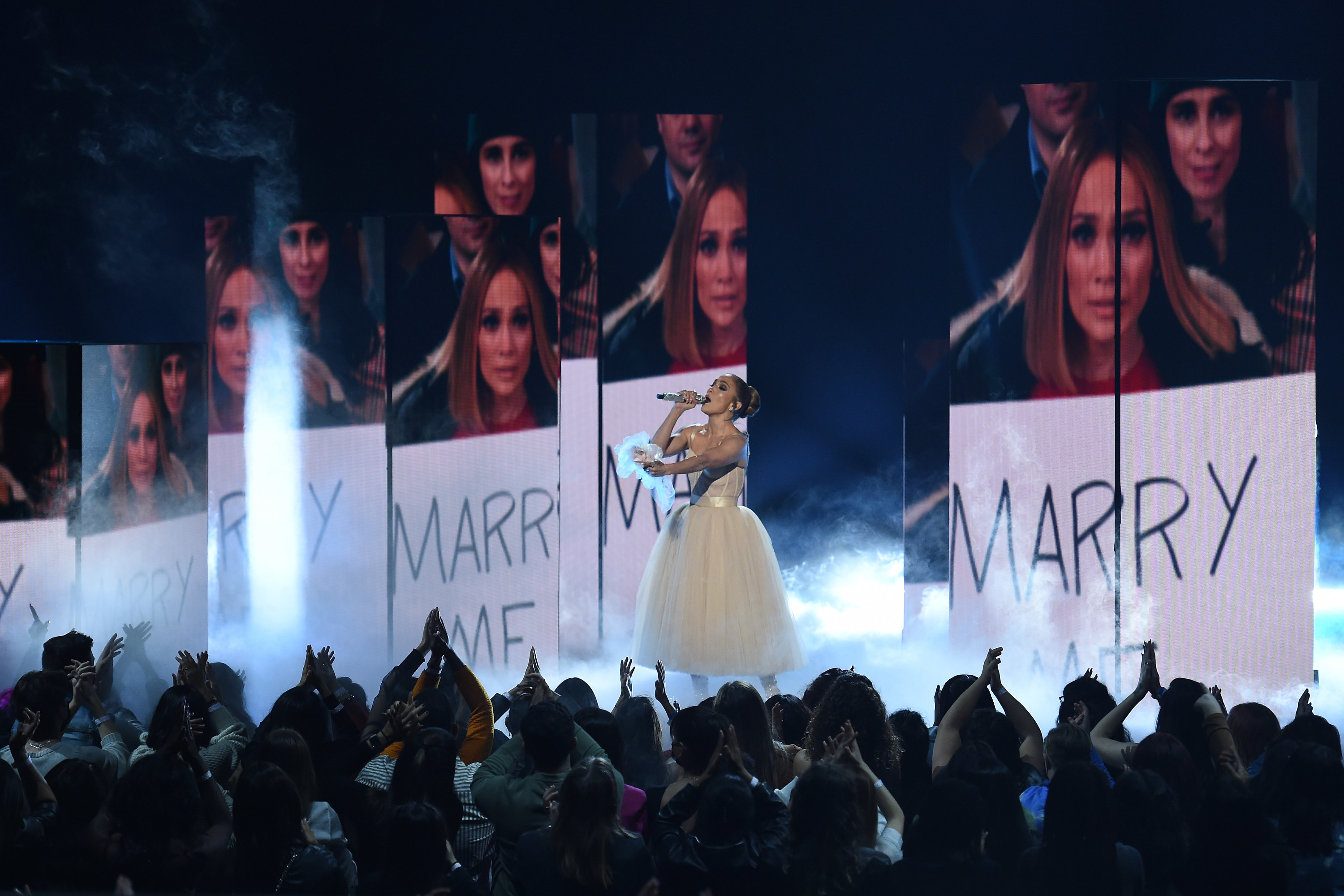 Jlo is performing in front of &quot;Marry me&quot; signs