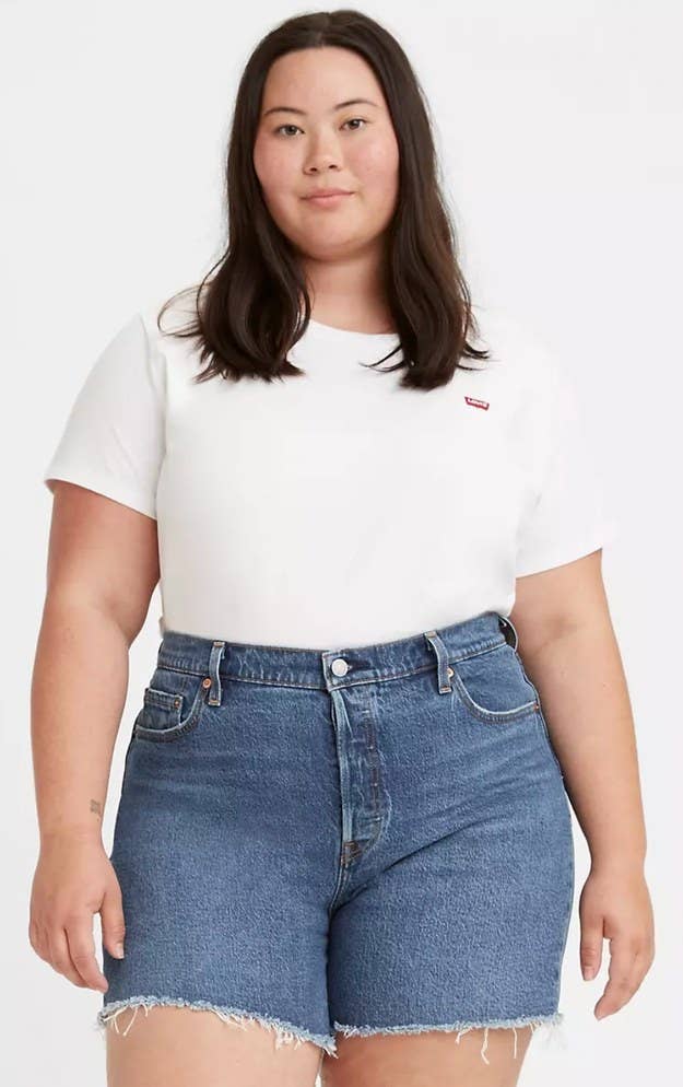 a model wearing the t-shirt with jean shorts