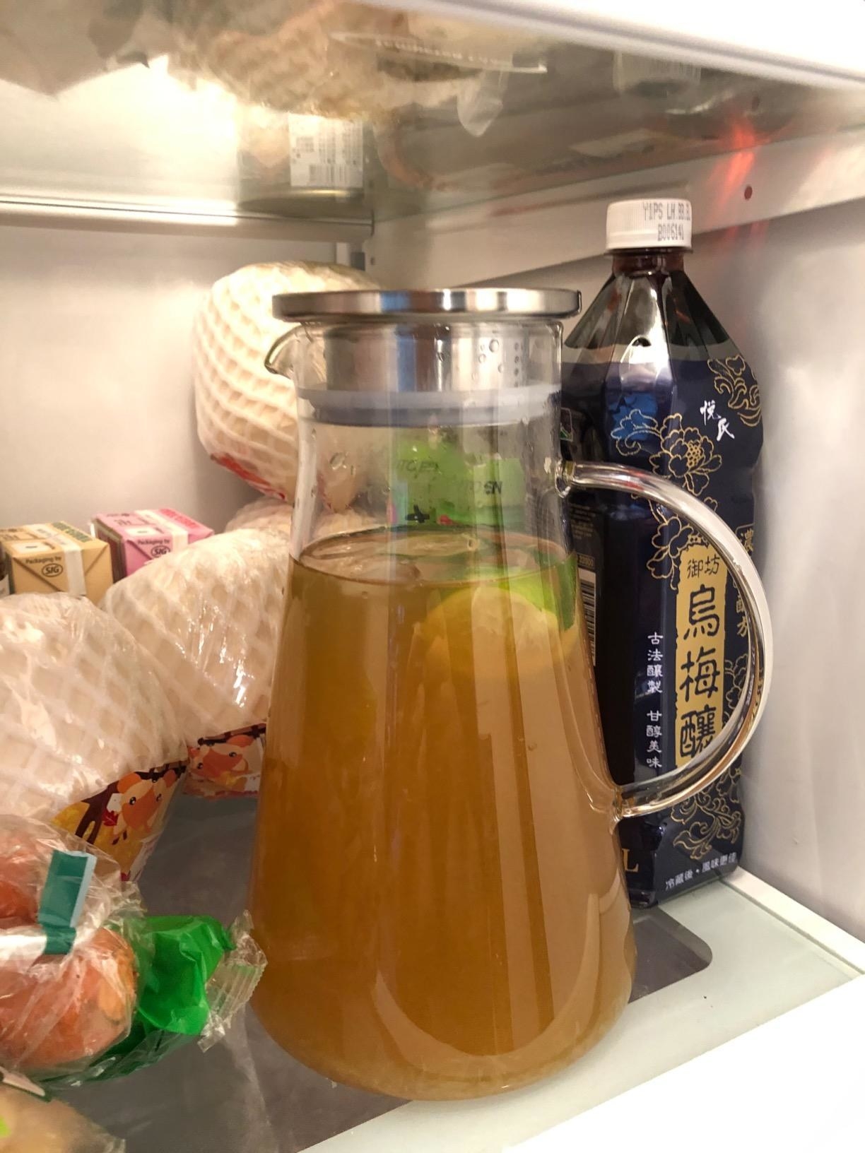 The glass pitcher filled with juice inside a reviewer's fridge