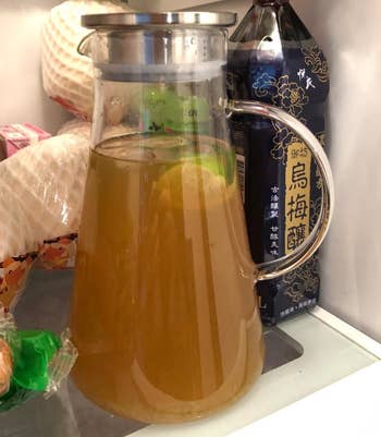 The glass pitcher filled with juice inside a reviewer's fridge