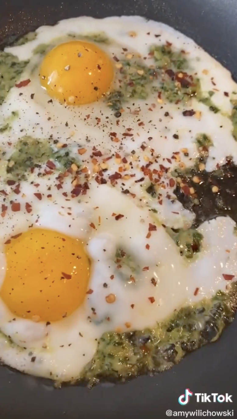 An egg fried in pesto and topped with chili flakes