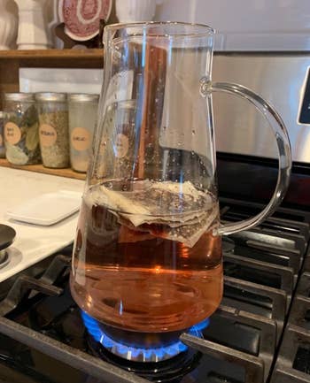 Reviewer photo of the glass pitcher being used to brew tea on a stovetop