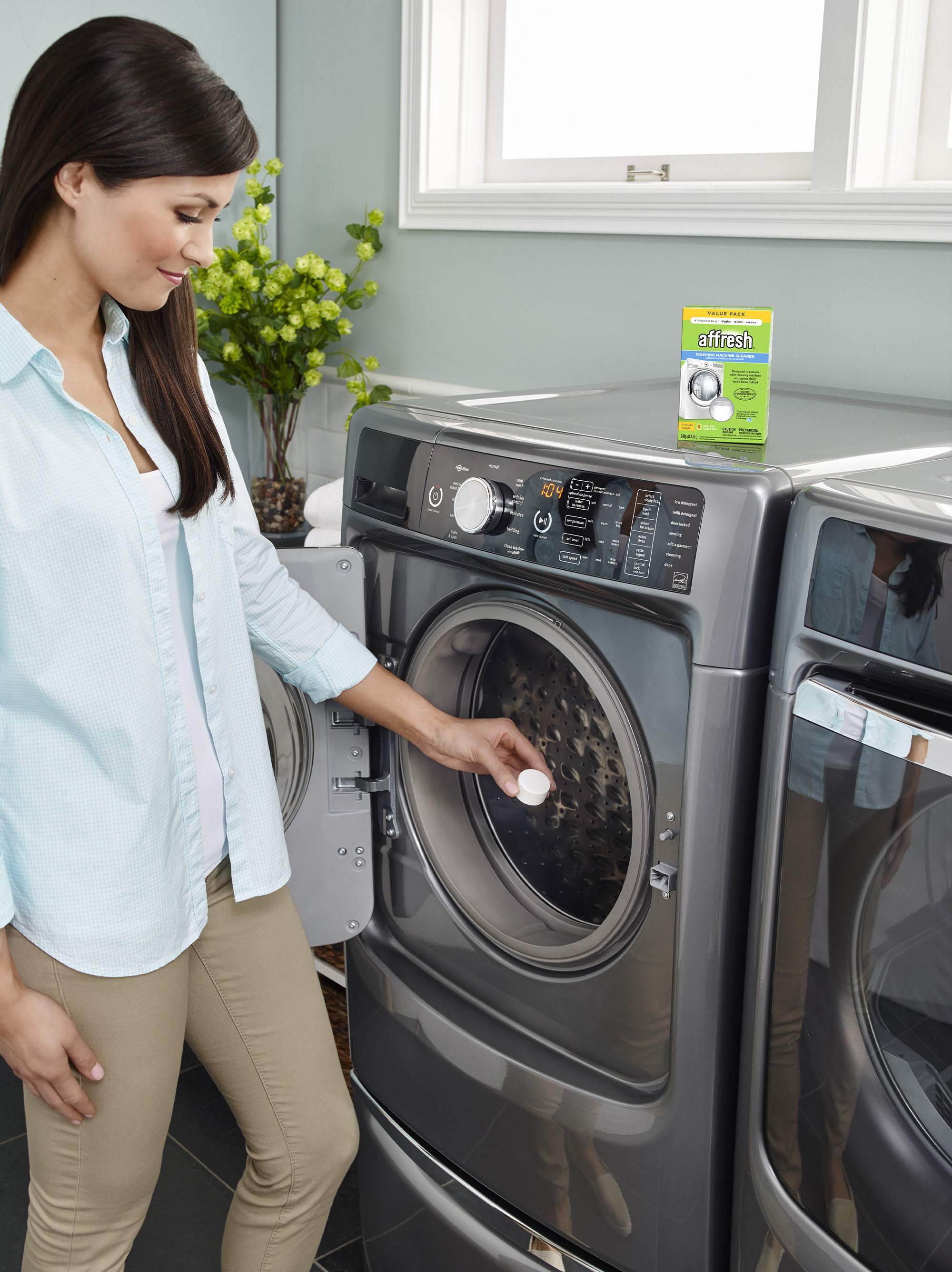 a person tossing the tablet into a front-load washing machine