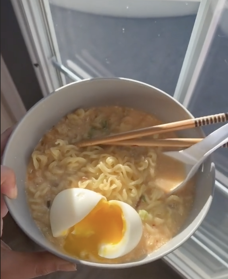 A bowl of creamy ramen with a soft-boiled egg
