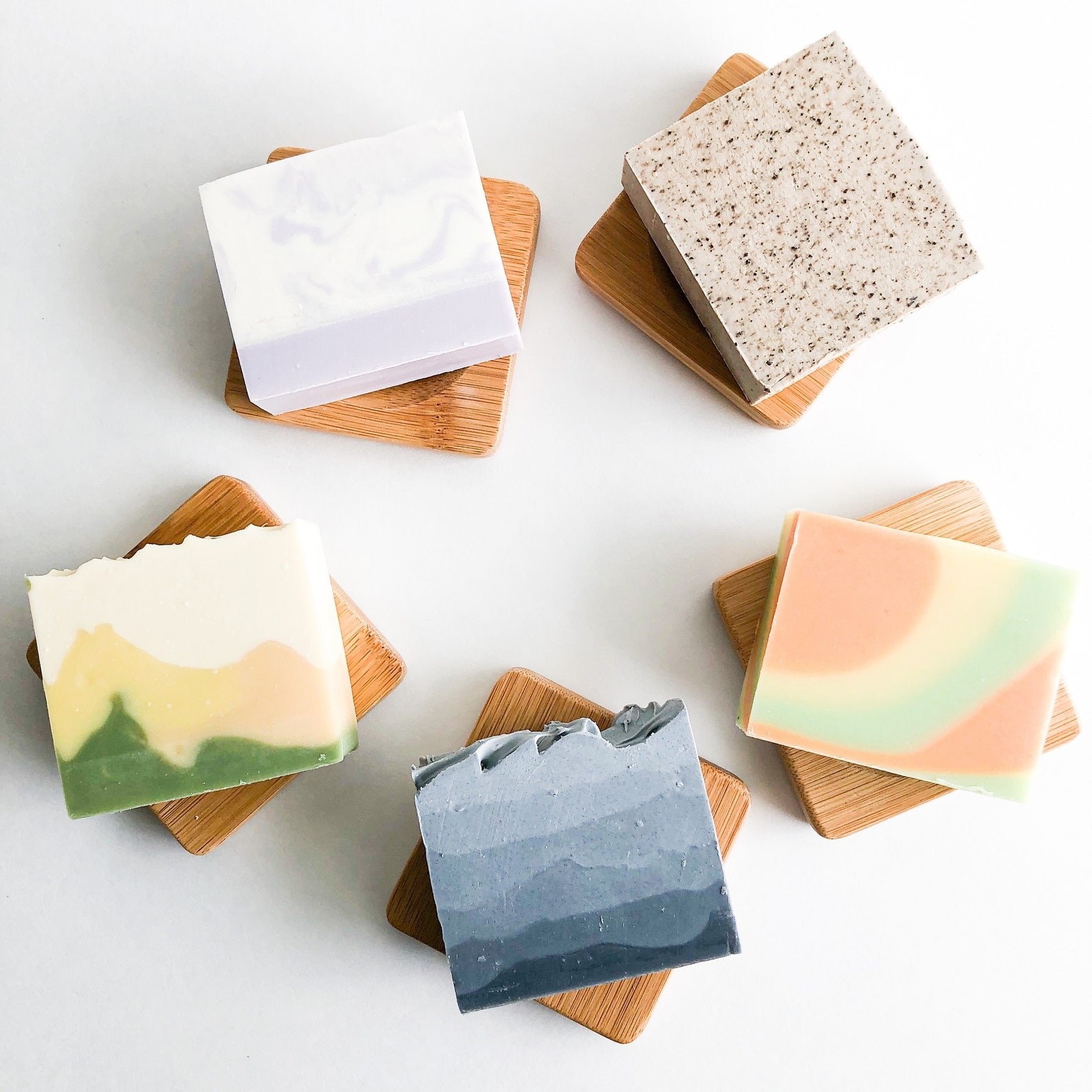 colorful bars of handmade vegan soap on wooden soap dishes